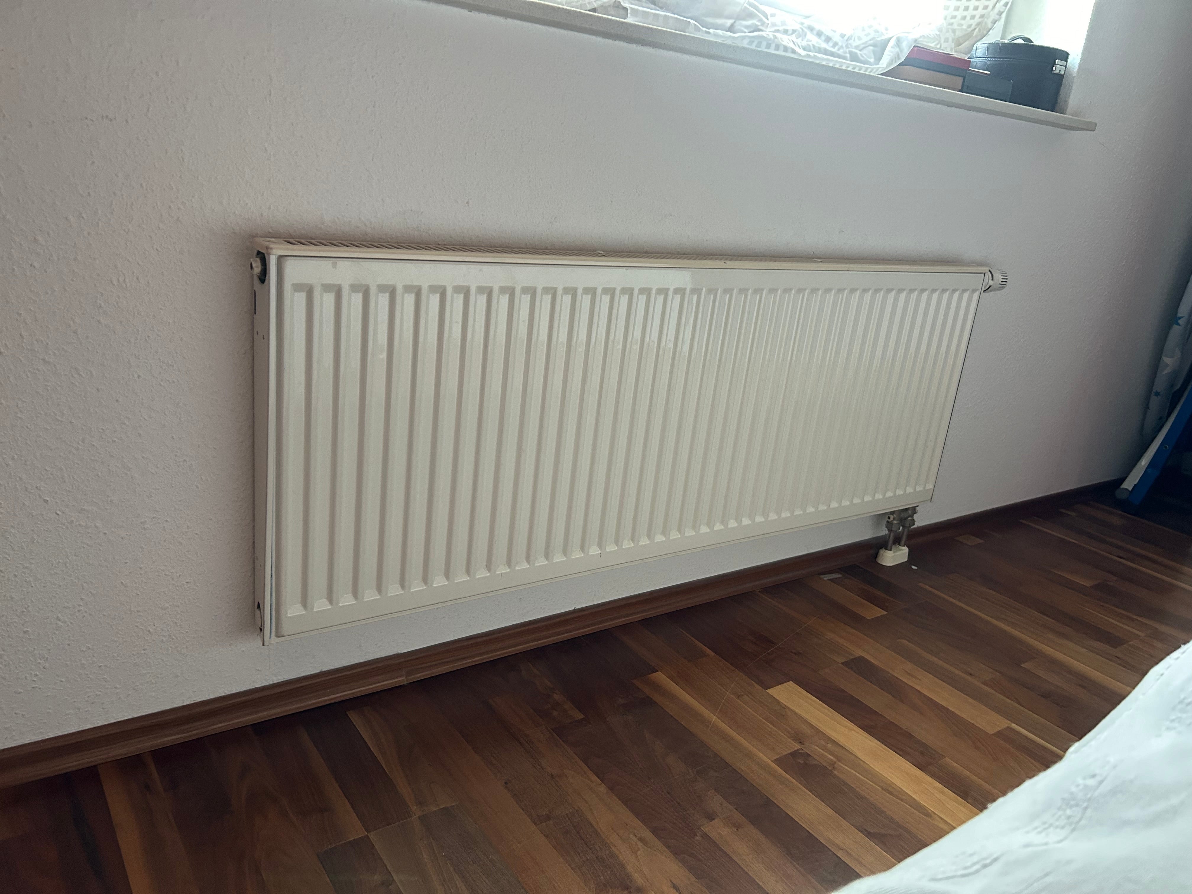 Ein Heizkörper ist unter einem Fenster.